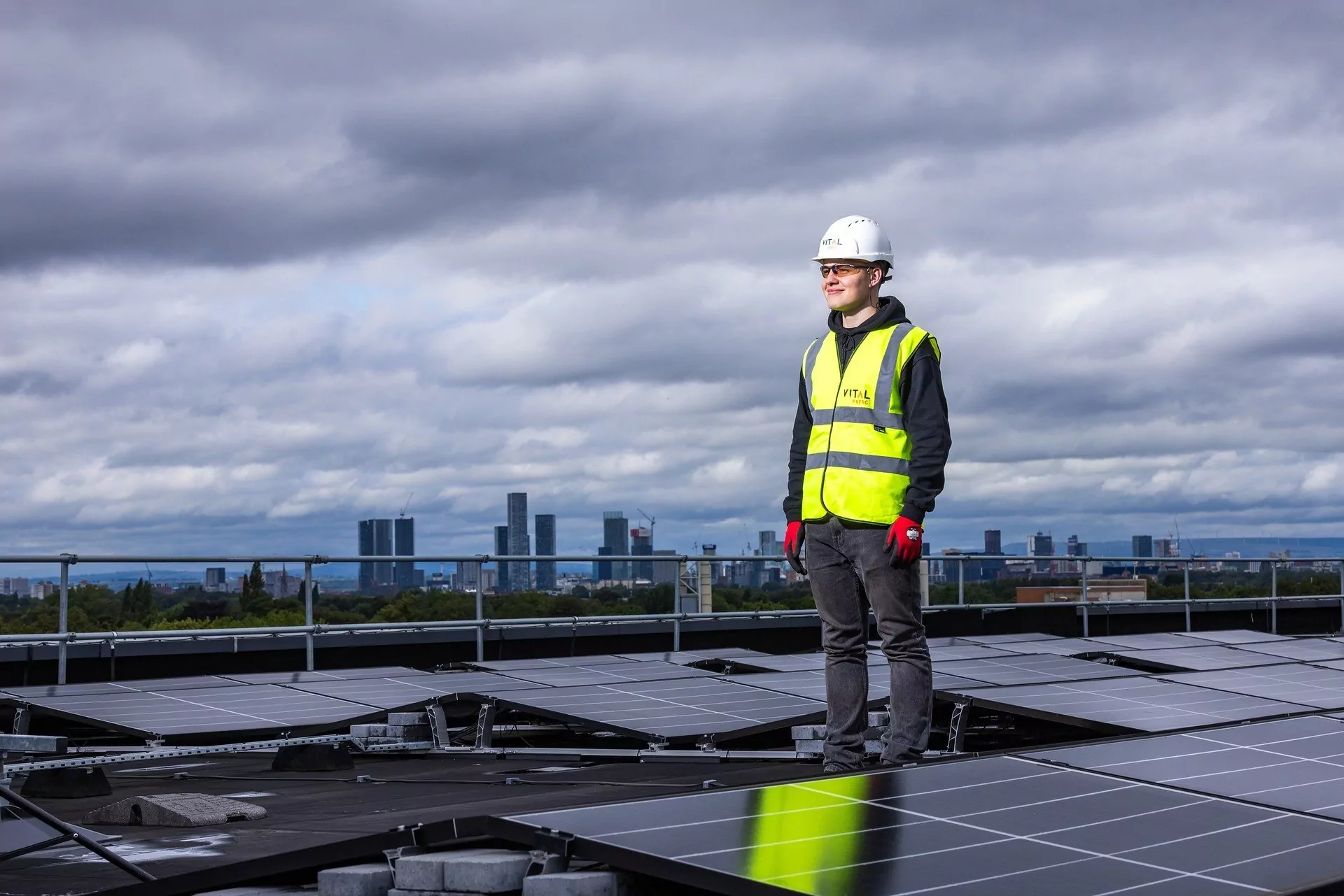 Trabalhador em cima de teto com painéis solares